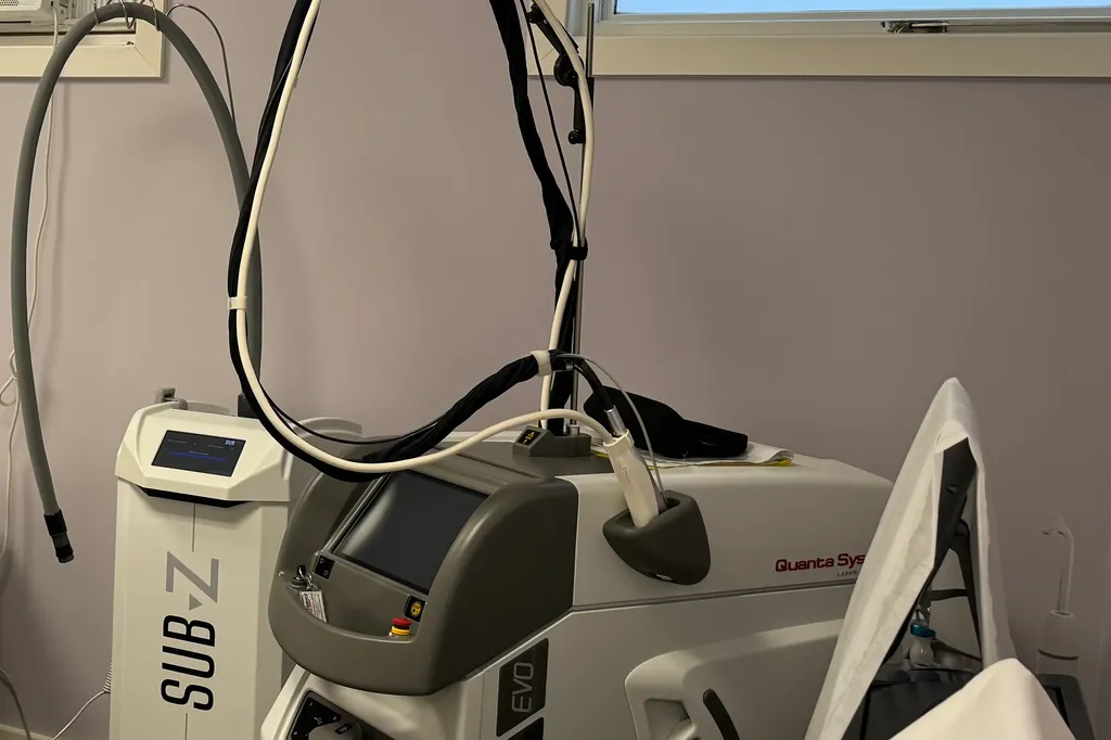 The laser hair removal system and its handpiece arm in the clinic's laser treatment room