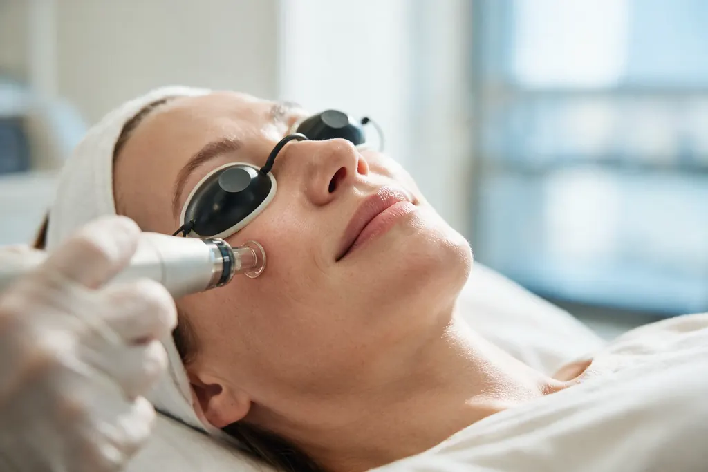 A woman wearing protective eyewear during a facial laser treatment