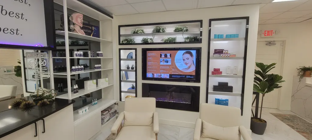 The clinic's lounge seating in front of the skincare display wall